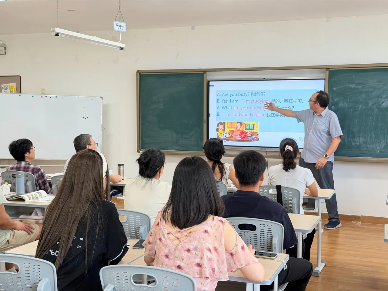 赛思外教在成人英语课堂讲解句型,学员围坐学习